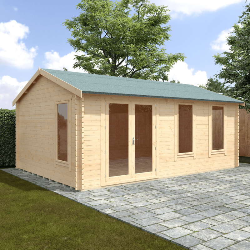 Wooden garden shed with a green roof on a paved area with grass and trees in the background