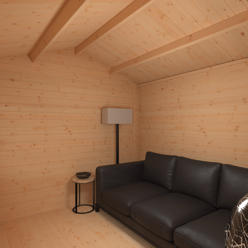 Modern black leather sofa in a wooden room with a lamp and small table.