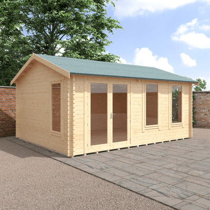Wooden garden shed with a green roof on a paved area with trees in the background