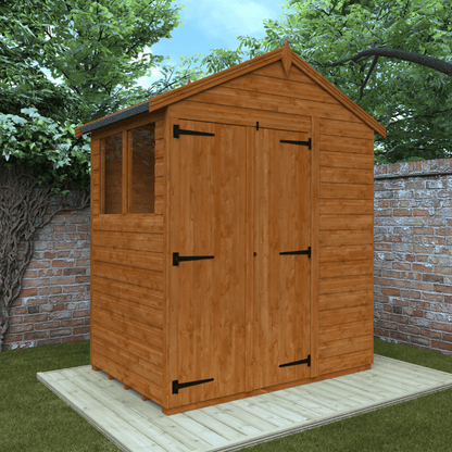 Wooden shed with a gabled roof in a garden setting with trees and a brick wall.
