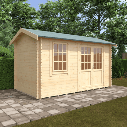 Wooden shed with a green roof on a paved area with trees in the background