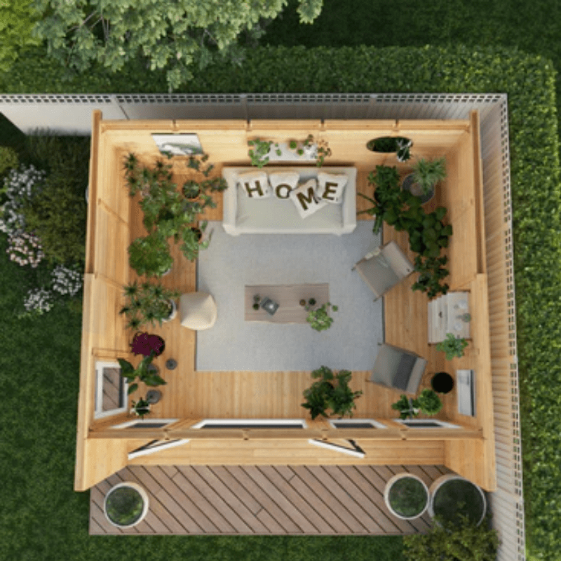 Top-down view of a small wooden house with furniture and plants on a grassy background
