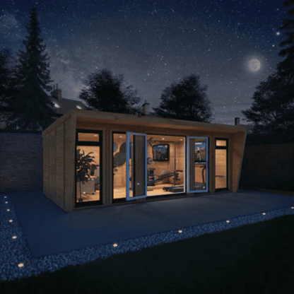 Modern cabin with large glass windows at night under a starry sky.