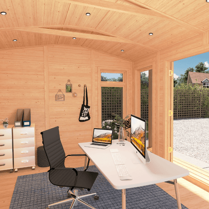 Wooden cabin office with a desk, chair, and computer setup.