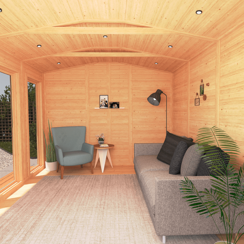 Wooden cabin interior with a gray sofa, armchair, and small table.