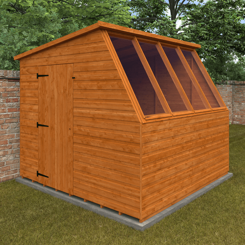 Wooden shed with a glass panel on a grassy area with trees in the background