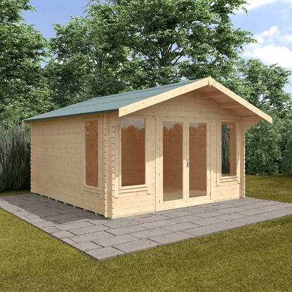 Wooden cabin with a green roof on a paved area surrounded by trees